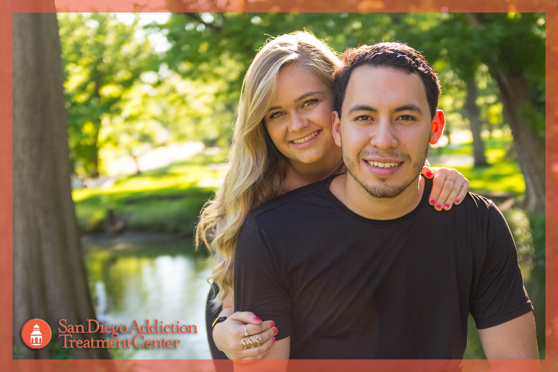 couple next to tree looking at camera and smiling