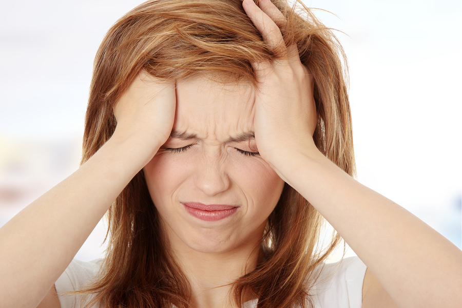 Teen woman with headache holding her hand to the head