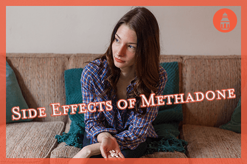 woman holding methadone pills in hand while sitting on couch