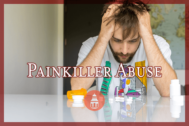 Distressed man looking down at pills strewn over table