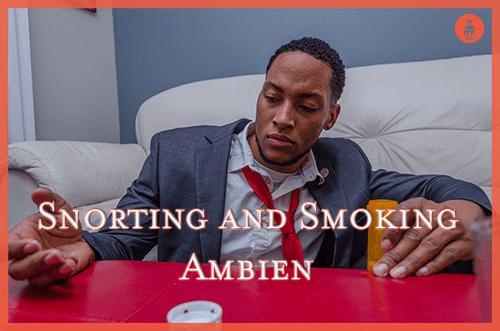 man on floor holding bottle of ambien in hand